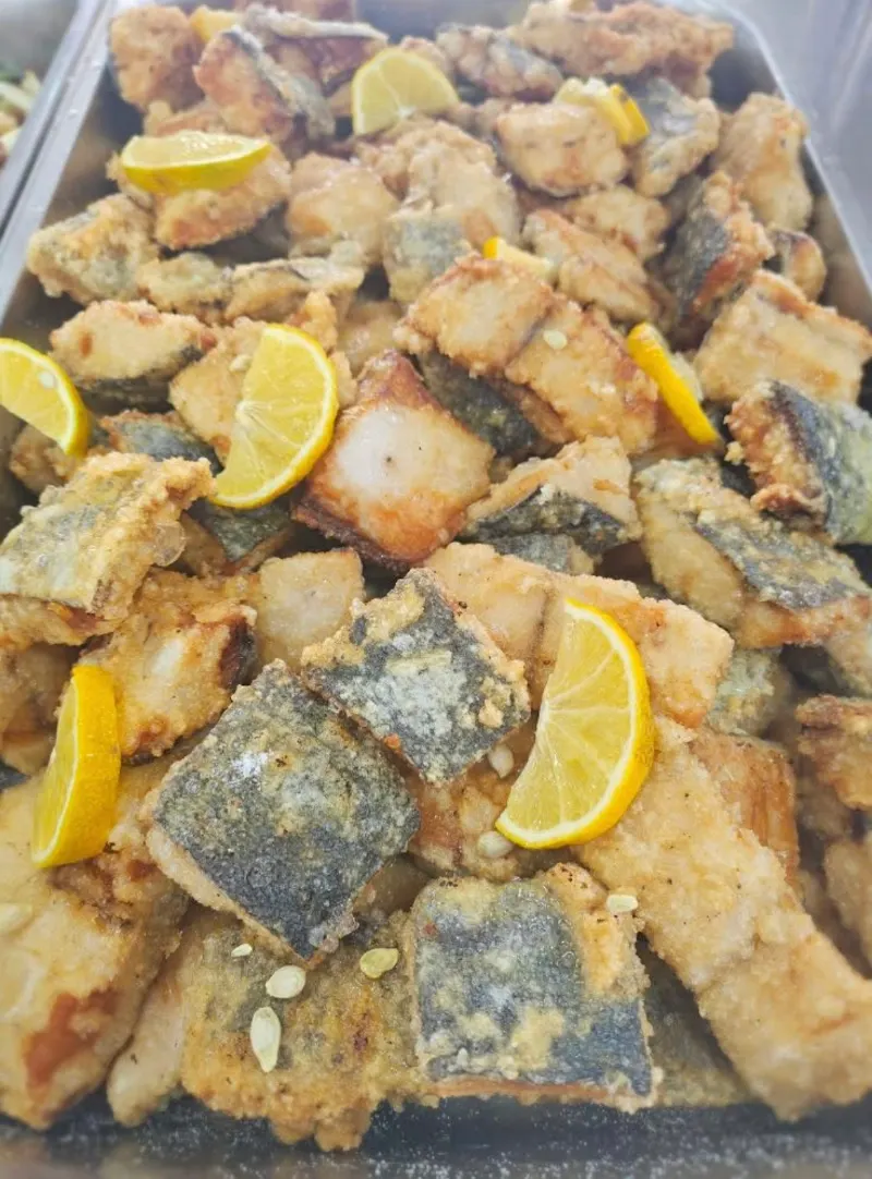 Un bac de morceaux de poisson panés avec des quartiers de citron